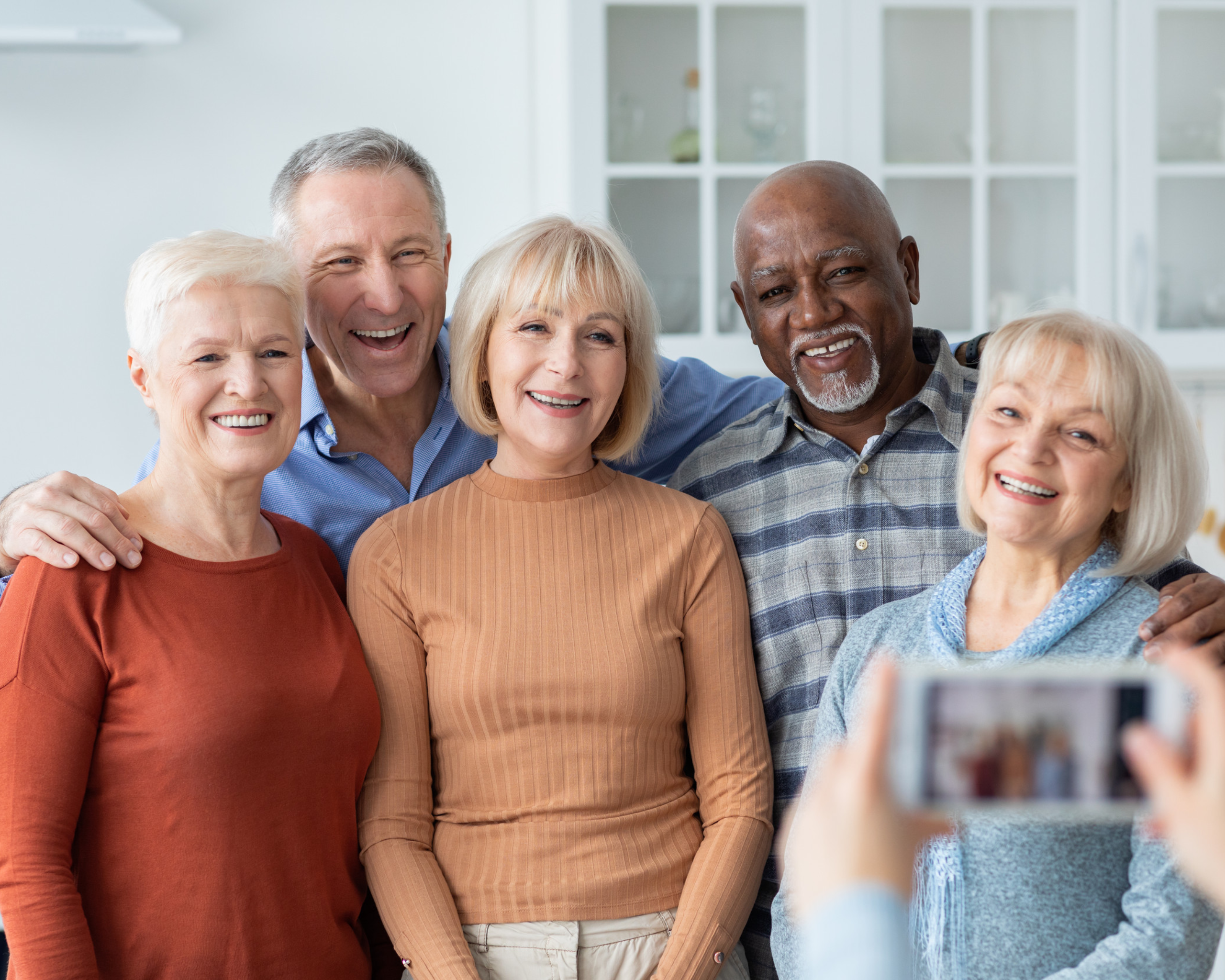 Unrecognizable person taking photo of multiracial group of senior people Unrecognizable person taking photo of multiracial group of senior people